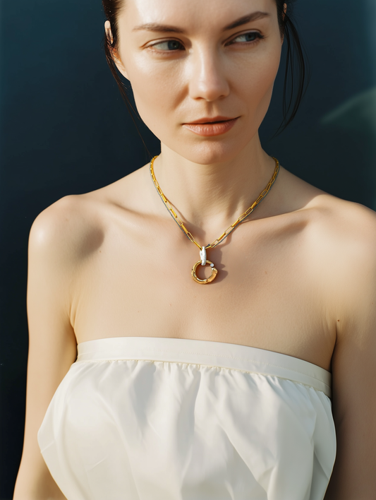 Woman wearing a gold necklace with a dark background