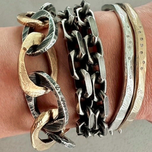 Skipping Stones Simple Bracelet in Bronze and Silver with White Diamonds. Layered with the Link Chain Bracelet in Mixed Metal. Middle Bracelet shown is no longer available.