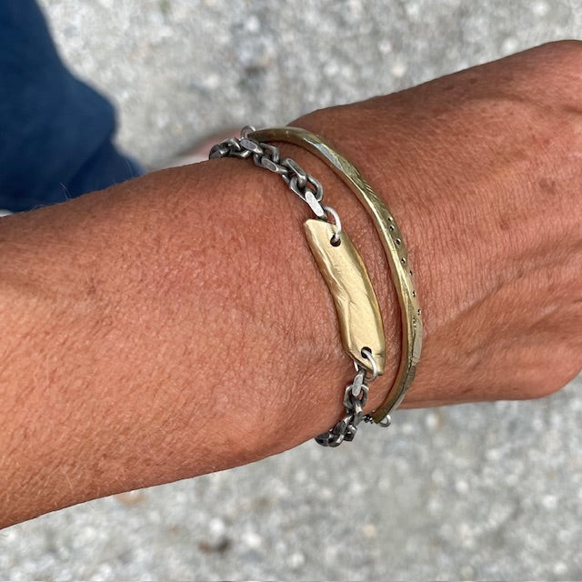 Close up of person wearing Pulse Bracelet in Bronze with the Skipping Stones Simple Bracelet in Bronze with Black Diamonds