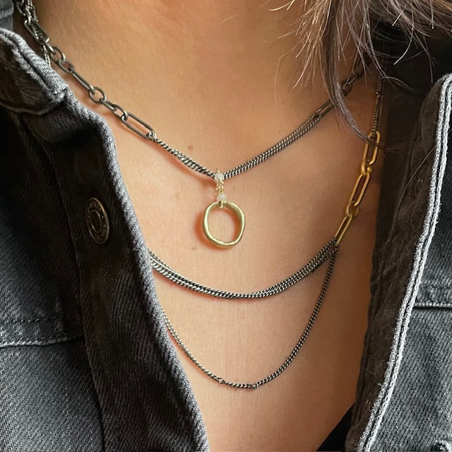 Eclipse Embrace Necklace Layered with Celestial Convergence Necklace on a person