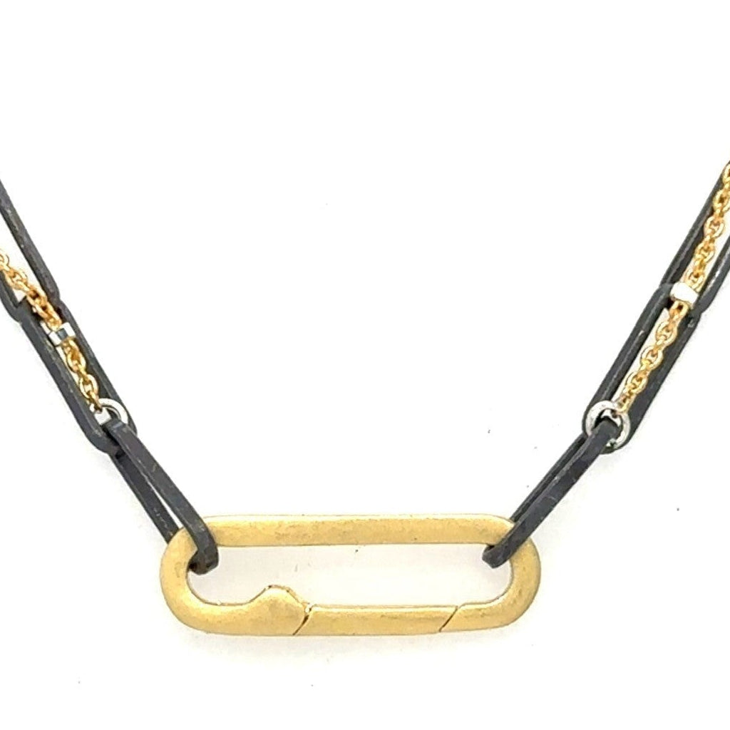 A blend of two worlds in one exquisite piece. This necklace features two chains: one in sophisticated black oxidized sterling silver and the other in luxurious 14K gold-filled metal. The contrasting tones create a subtle yet striking visual interest, perfect for those who appreciate nuanced style.