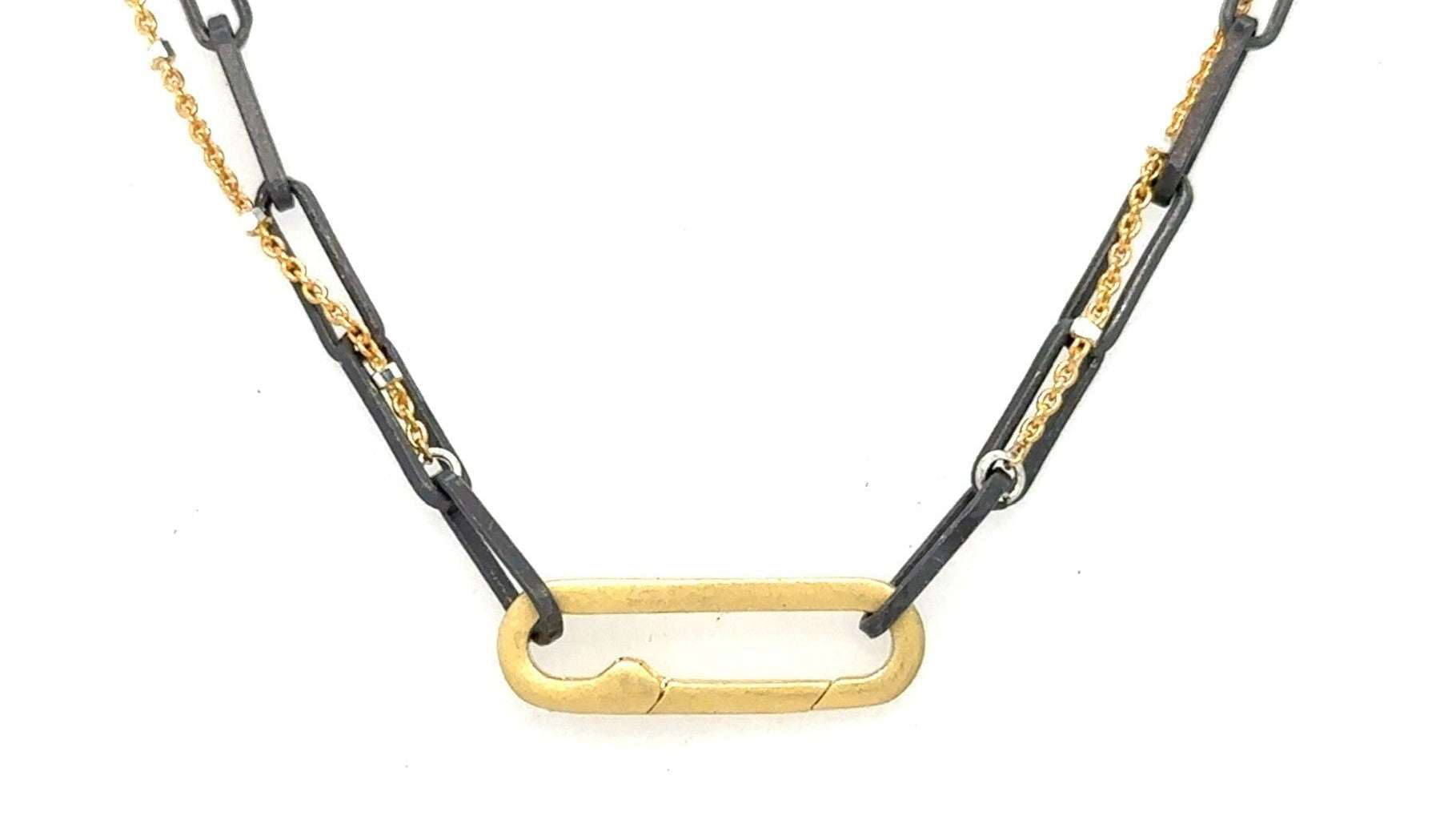 A blend of two worlds in one exquisite piece. This necklace features two chains: one in sophisticated black oxidized sterling silver and the other in luxurious 14K gold-filled metal. The contrasting tones create a subtle yet striking visual interest, perfect for those who appreciate nuanced style.