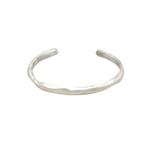 The Current Cuff is subtle strength, distilled into form. Hand-forged in sterling silver, this 1/4" wide cuff flows in a clean, sculptural line that curves naturally around the wrist. It’s designed for effortless wear and timeless versatility.
