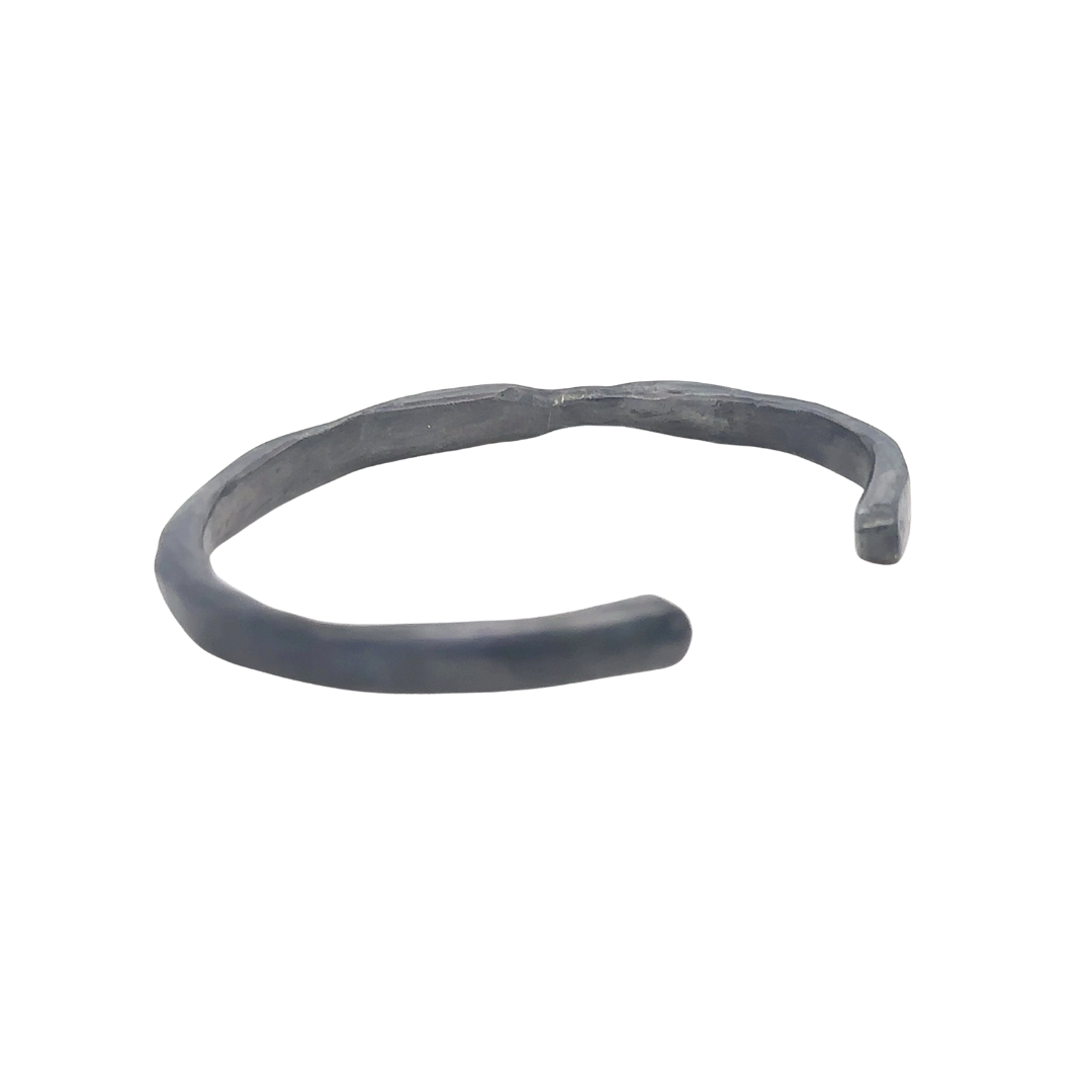 The Divine Light Cuff is a slender oxidized silver cuff illuminated with white diamonds. A symbol of serenity and luminous strength. Back side view.