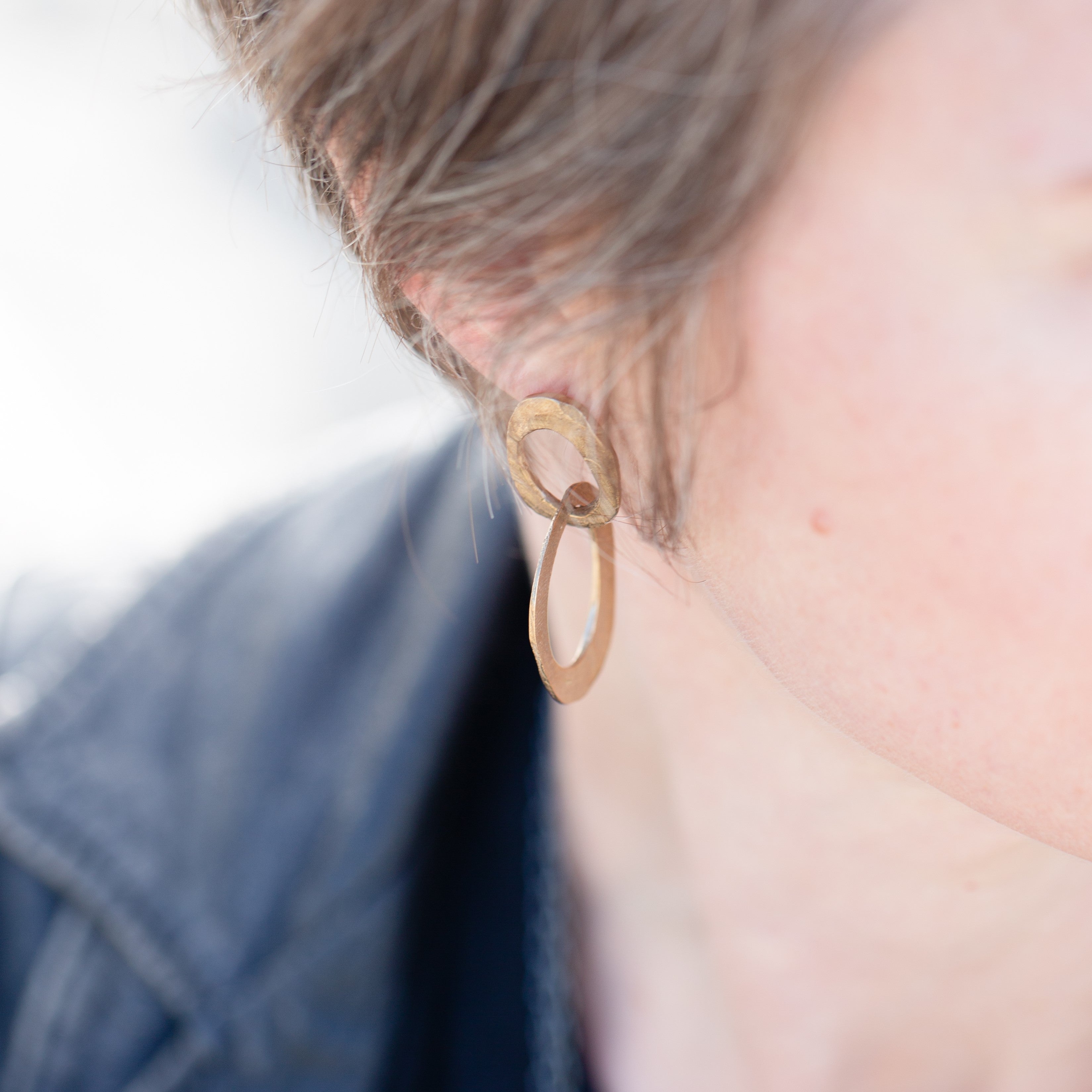 Close up of the Skipping Stones Double Oval Earrings in Bronze on Model