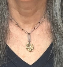 The Love Talisman Necklace worn by a person with gray hair.