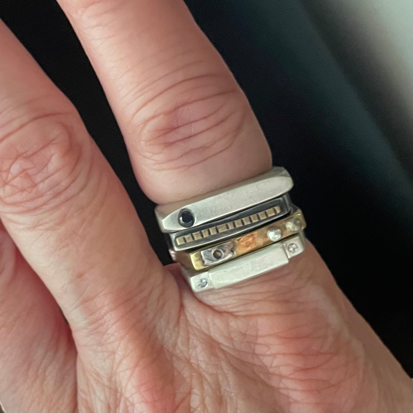 Close-up of Lunar Eclipse Ring in silver with the Trinity Stack on a person