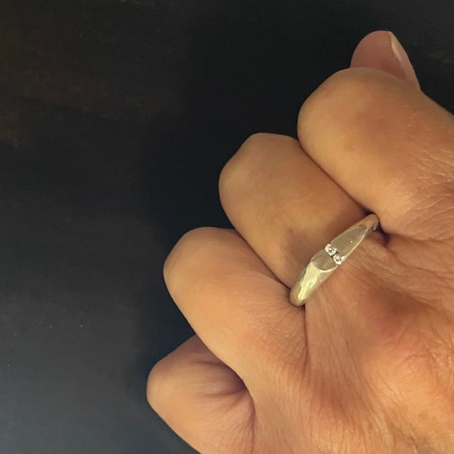 The Channel Ring is designed to channel your desires and aspirations, empowering you to manifest your dreams with unwavering determination. Handcrafted with the ancient lost wax casting technique, the 2 to 4mm organic band is sterling silver and features two brilliant 2mm white diamonds symbolizing harmony and balance.