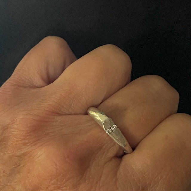 The Channel Ring is designed to channel your desires and aspirations, empowering you to manifest your dreams with unwavering determination. Handcrafted with the ancient lost wax casting technique, the 2 to 4mm organic band is sterling silver and features two brilliant 2mm white diamonds symbolizing harmony and balance.