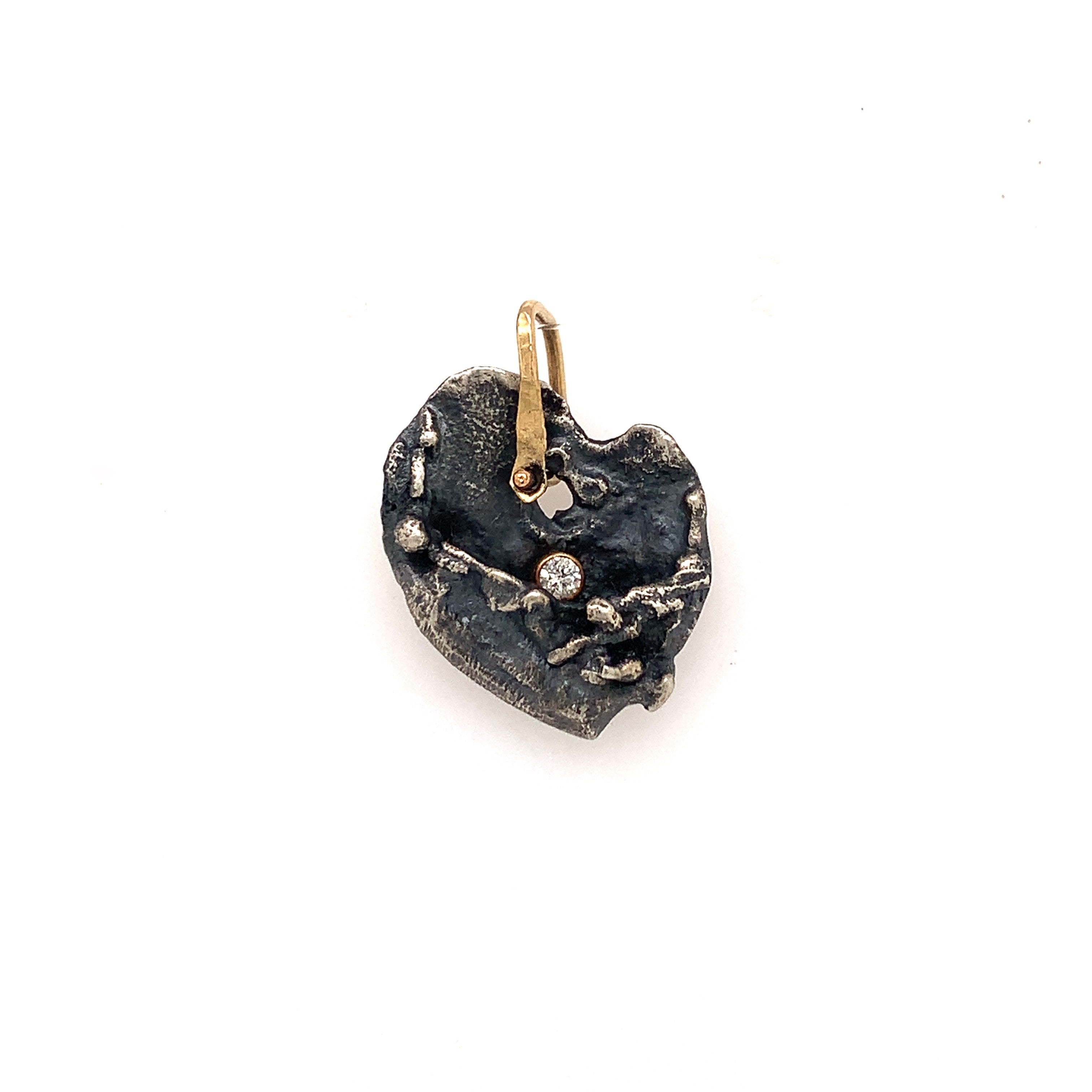 The Love Talisman designed as a heart-shaped talisman with textured patterns and a small diamond at the top center.