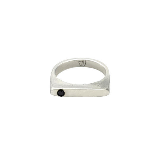 This sleek, architectural band captures that moment of clarity with its refined silhouette and single black diamond - like the dark center of an eclipse where revelation occurs in shadow.