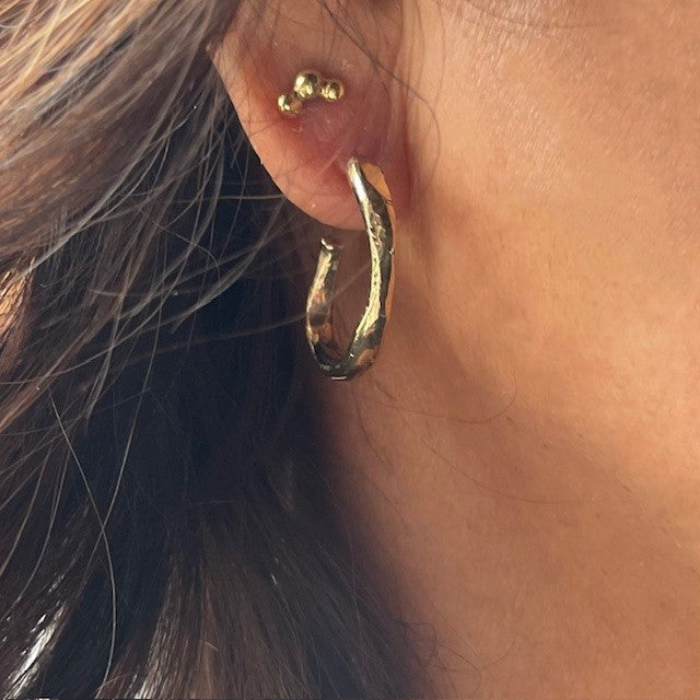 Hoshi Stud Earrings and Satori Hoop Earrings on a person