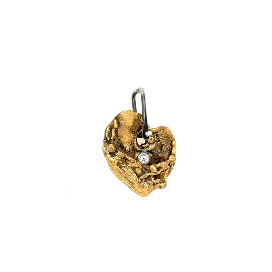 The Love Talisman designed as a heart-shaped talisman with textured patterns and a small diamond at the top center.