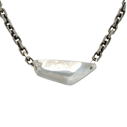 The Vestige Necklace carries the strength of what remains. A bold, sculptural form rests at the center, solid and commanding, yet at its edges, fragments break away. It's a reminder that awakening is not about what we lose, but what endures.
Suspended on a bold oxidized chain, the 18" Vestige Necklace sits close to the heart, grounding you in presence and sovereignty. The weight is intentional, the form unapologetic.