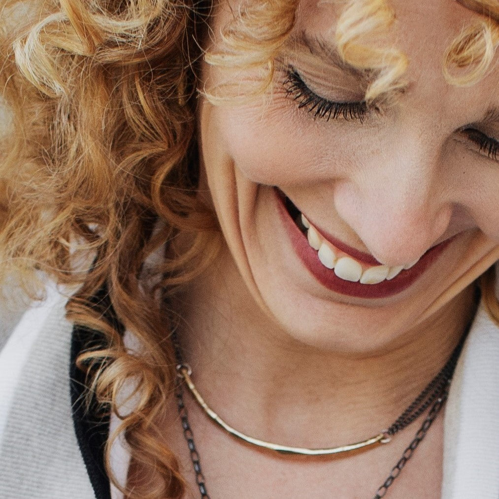 Close-up of a woman with curly hair smiling