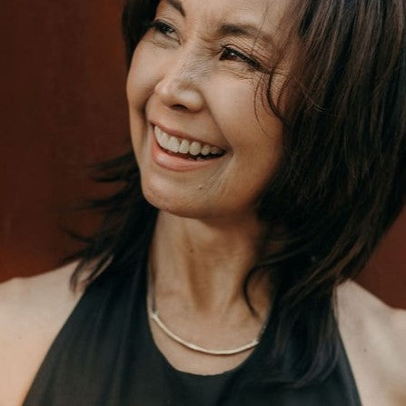 Woman with a warm smile against a brown background