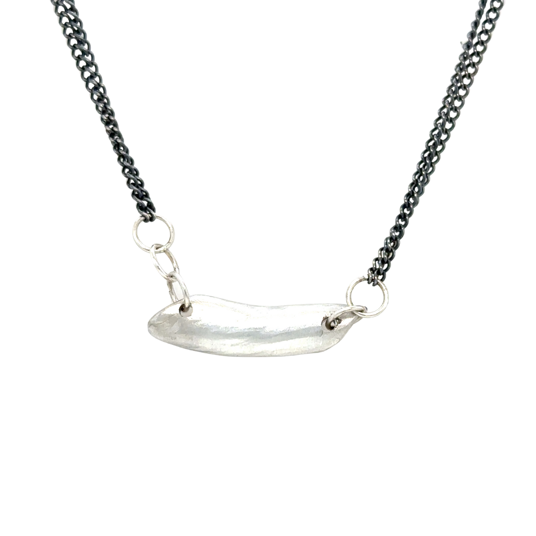 The Whisper Necklace rests softly at the nape of your neck, like a secret promise you carry close. A sculptural form anchors dual oxidized silver chains and it's raw edges are a reminder of the beauty that emerges from imperfection.