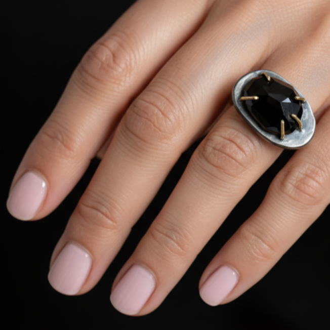 Close up of the onyx ring with small gemstone closeup on model's hand.