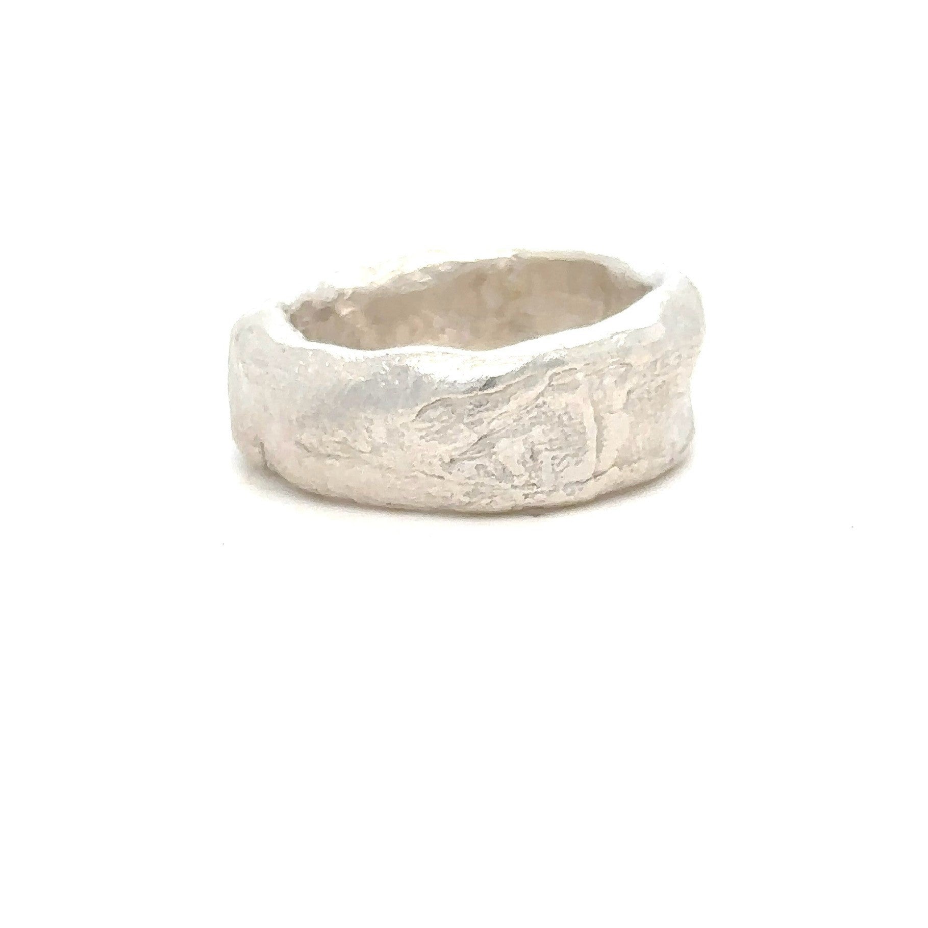 Silver ring with a textured surface on a white background