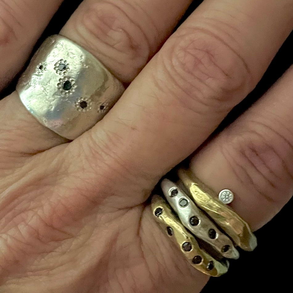 The Five Elements Ring in Silver with other stacking rings shown on persons hand