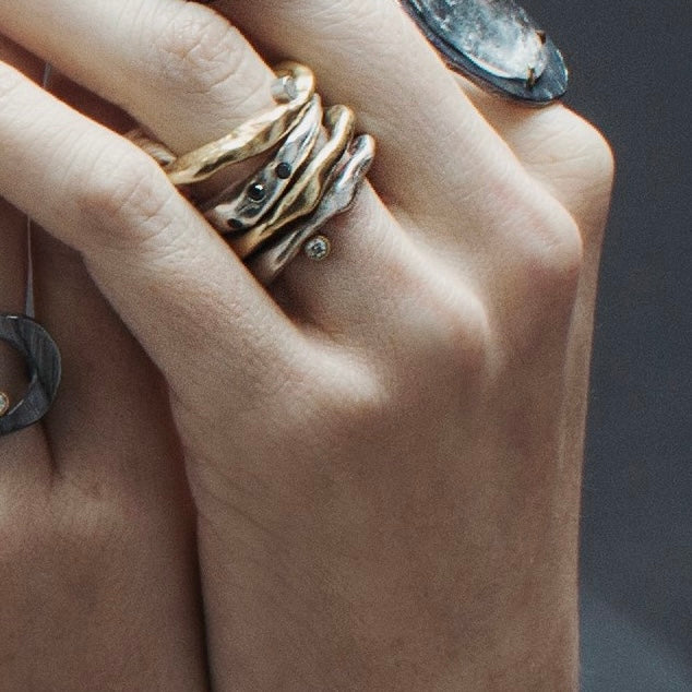 Various Chikahisa Studio Rings stacked shown on Model