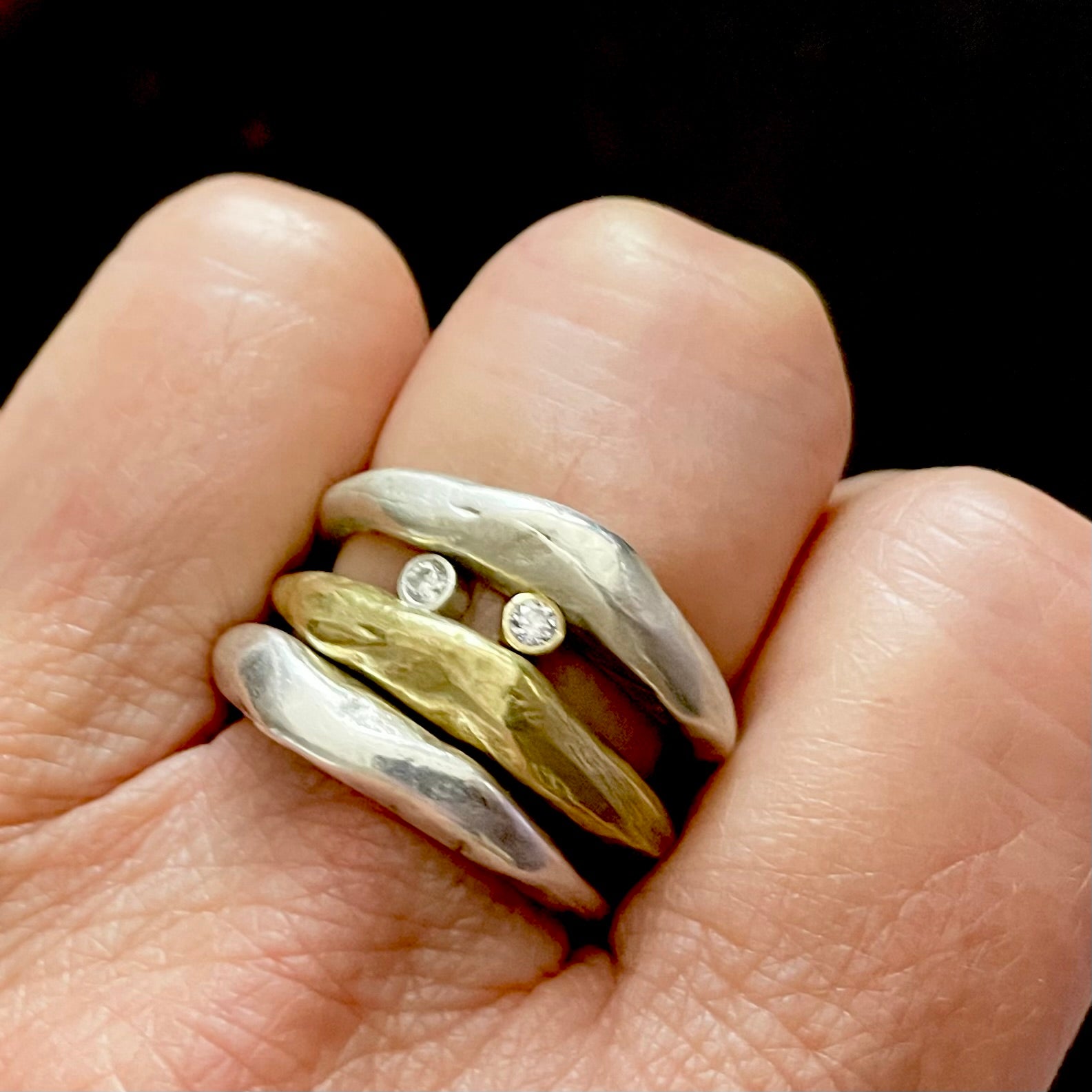 Close up of Silver and Bronze Odyssey Rings with Silver Element Ring on hand