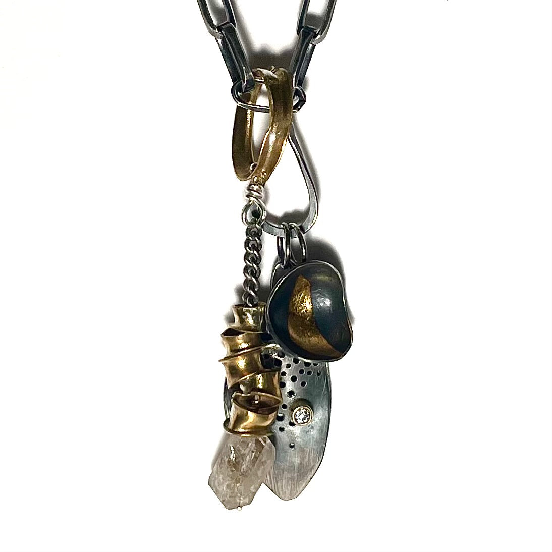 The Rooted Talisman draws its inspiration from the awe-inspiring design and functionality of the human spinal cord. Much like the intricate network of the spine, this talisman symbolizes strength, resilience, and the remarkable agility that resides within the core of our being.  Shown here on Oxidized Silver Chain with Tear Drop Connector and Desire and Truth Talisman Pendants.