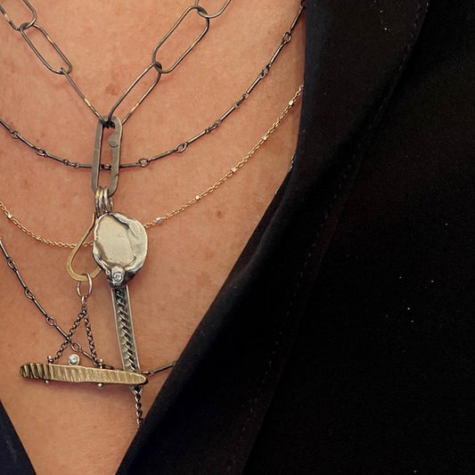 Close up of the Balance, Reflection, and Strength Talisman Pendants and the Layered Necklace in Mixed Metal.