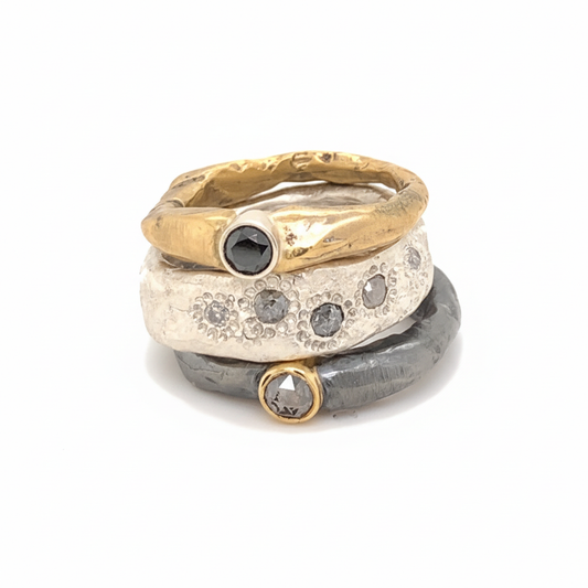 Ring stack featuring (top to bottom) Devotion Ring in Bronze w/Black Diamond; Thrive Ring with Salt and Pepper Diamonds; Devotion Ring in Oxidized silver with Salt and Pepper Diamond.