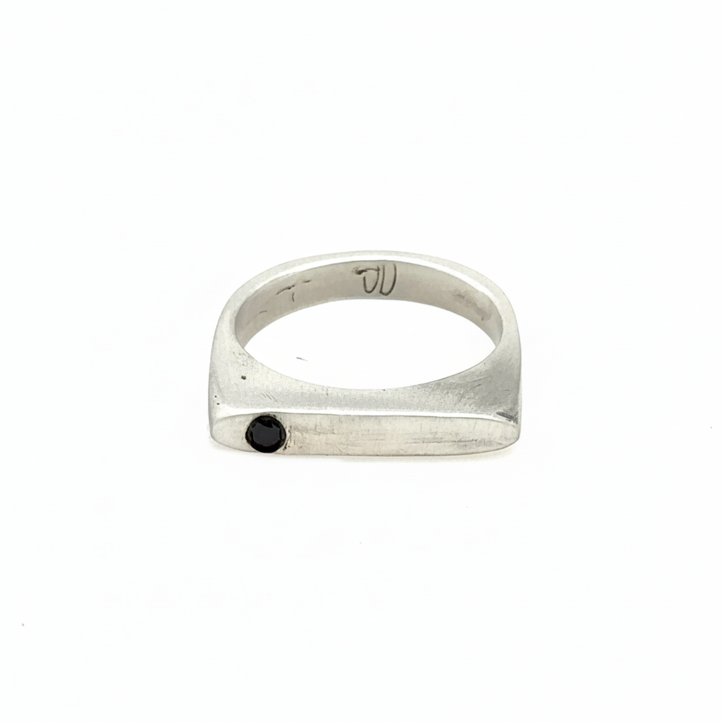 This sleek, architectural band captures that moment of clarity with its refined silhouette and single black diamond - like the dark center of an eclipse where revelation occurs in shadow.