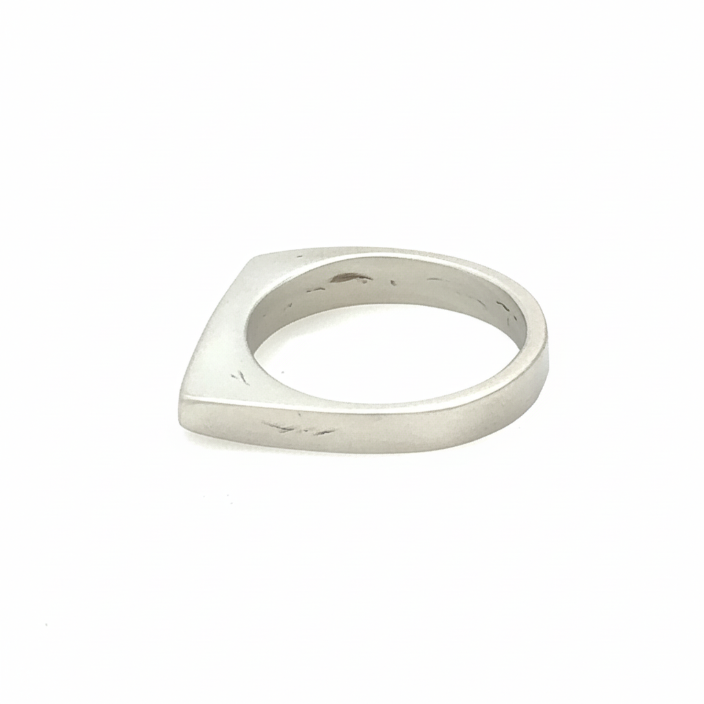 Side view of this sleek, architectural band captures that moment of clarity with its refined silhouette and single black diamond - like the dark center of an eclipse where revelation occurs in shadow.