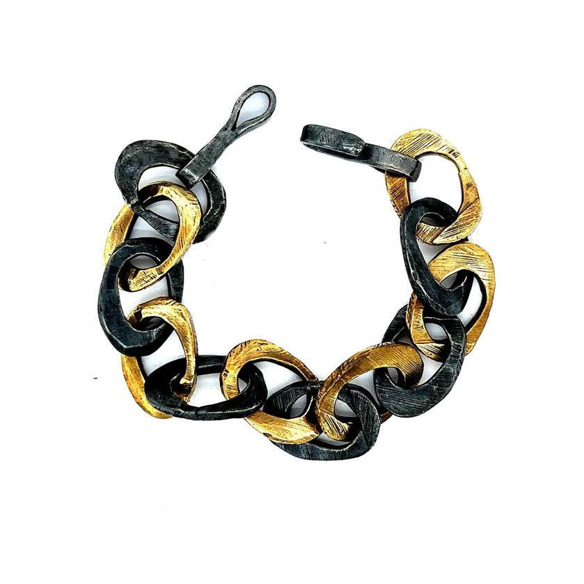 This exquisite piece combines the warmth of bronze and the cool sophistication of oxidized sterling silver in a harmonious design. This bracelet features intricately woven strands that symbolize the interconnectedness of life's experiences. The adjustable clasp ensures a perfect fit for any wrist size.