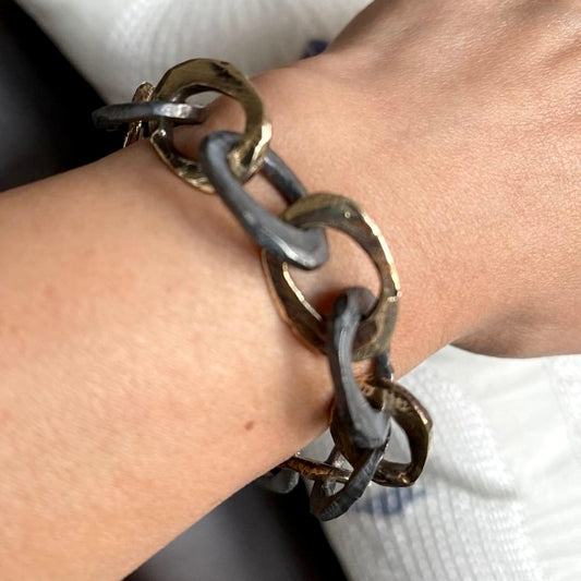 This exquisite piece combines the warmth of bronze and the cool sophistication of oxidized sterling silver in a harmonious design. This bracelet features intricately woven strands that symbolize the interconnectedness of life's experiences. The adjustable clasp ensures a perfect fit for any wrist size.