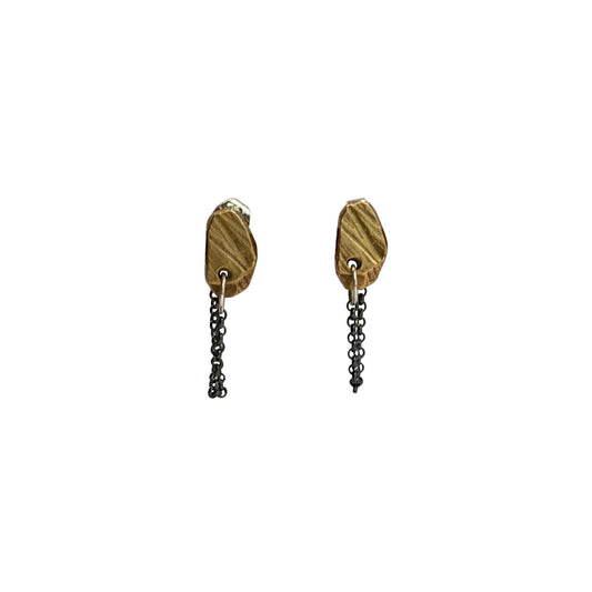 The Stone Stud with Chain Earrings feature a classic stud design, elevated by a delicate chain that drapes gracefully from the lobe. The attached chain adds movement and intrigue, creating a dynamic look that's both sophisticated and playful. Their versatile design allows for various wearing styles - traditionally in the lobe, or creatively styled up the ear for a more dramatic effect.