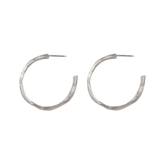 Our Small Hoop Earrings feature the same richly textured surface as their larger counterparts, evoking the weathered elegance of historic monoliths in a more subtle form. The Small Hoops are designed for versatility, perfect for everyday wear or as part of a curated ear stack.