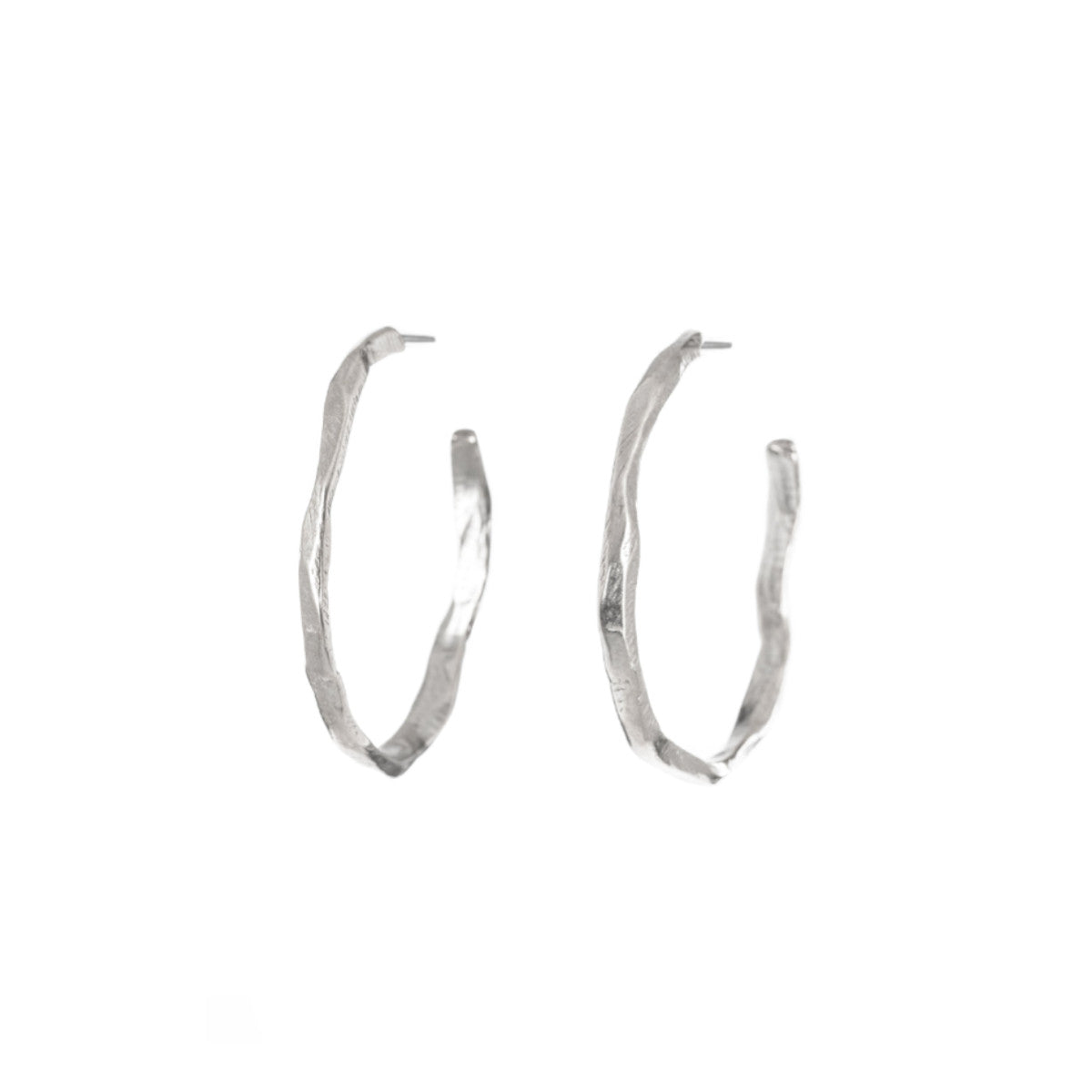 A bold re-imagining of the classic hoop earring. These striking pieces feature a richly textured surface that evokes the weathered, timeless beauty of ancient monoliths. The Stonehenge Hoops are designed to elevate any look, from casual day wear to elegant evening attire. Their substantial presence ensures they make a statement, while the carefully balanced proportions keep them comfortable for all-day wear.