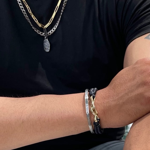 The Interwoven Bracelet is inspired by the profound significance of connections and relationships that we weave into our lives. Each delicate thread of leather and bold bronze clasp symbolize the intertwining bonds we form with others.