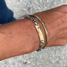 Close up of person wearing Pulse Bracelet in Bronze with the Skipping Stones Simple Bracelet in Bronze with Black Diamonds