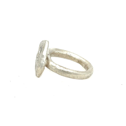 The surface of celestial bodies tells the story of their transformation – impacts and eruptions that forever changed their landscape. This textured disc ring captures that same raw beauty that mimics the terrain of distant worlds and the scattered diamonds appear like stars emerging from cosmic dust.
