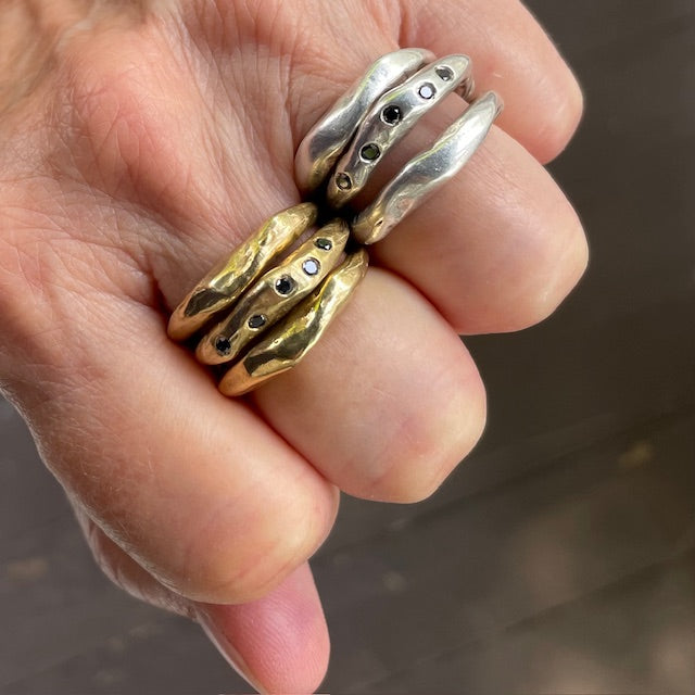 The Connection Stacking Ring Sets in Silver and Bronze shown on persons hand 