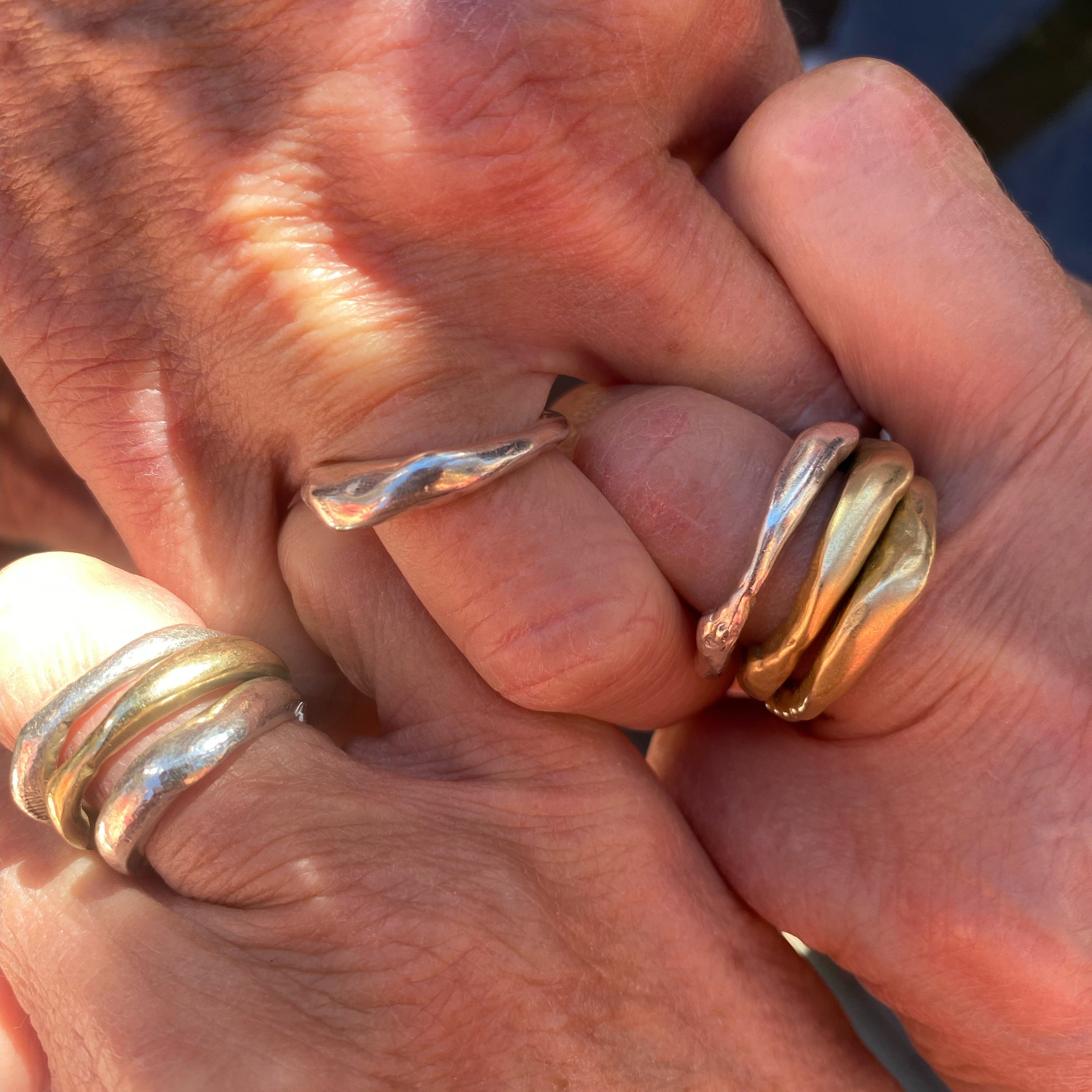 Close-up of hands wearing Alchemist Stacking Rings and Single Element Ring 