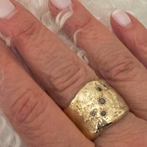 Close up of Five Elements Ring in Bronze on persons hand 