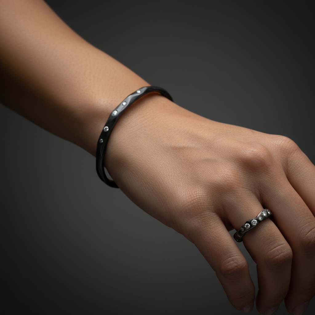 The Divine Light Cuff is a slender oxidized silver cuff illuminated with white diamonds. A symbol of serenity and luminous strength. Shown with Mystic Radiance Ring.