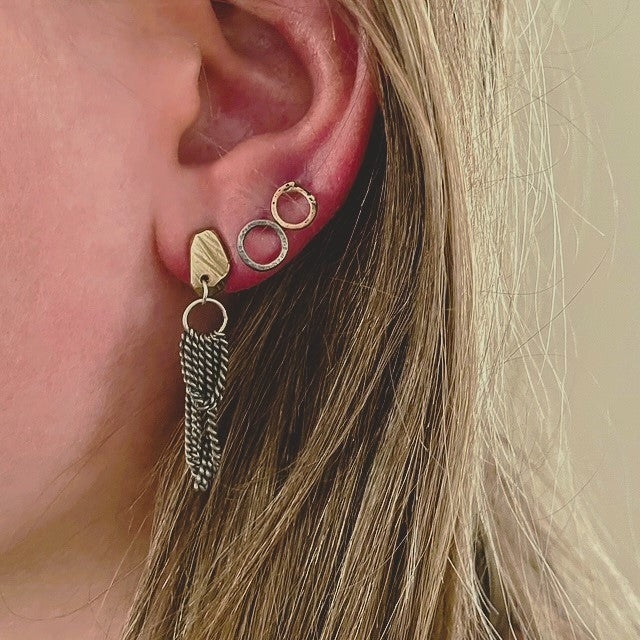 Experience the gentle allure of Whidbey Island's hidden waterfalls with our Cascade Studs. They capture the essence of water's delicate journey from stone to sea, embodying the island's secret, shimmering cascades.

Each stud features a small, intricately textured piece that evokes the rugged beauty of Whidbey's rocky outcrops. The surface mirrors the weathered stones shaped by centuries of flowing water and catches the light much like sunlight playing on rippled water, adding a subtle sparkle.