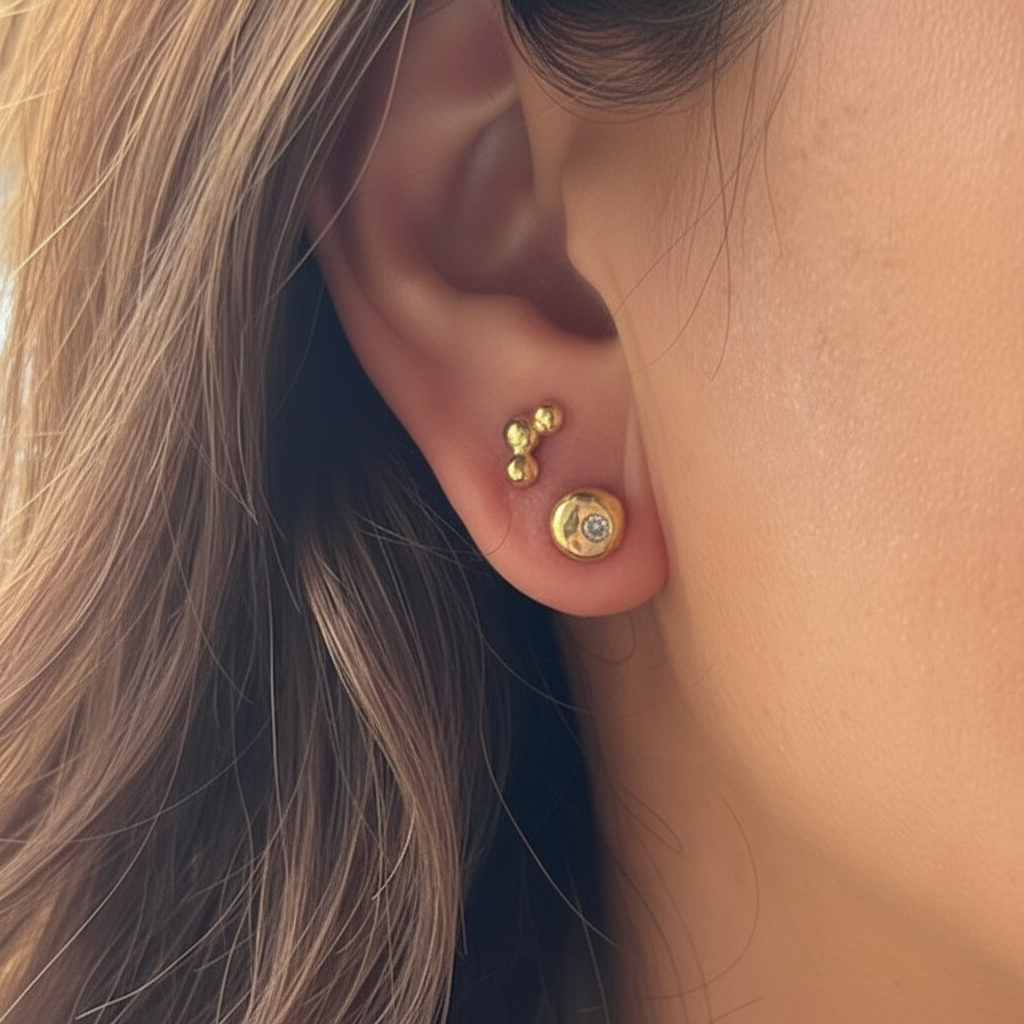Evil Eye Stud Earrings n 18kt Gold and Hoshi Stud Earrings in 18kt Gold on a person 