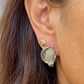 Reflection Talisman Earrings and Evil Eye Stud Earrings in 18kt Gold on a person 