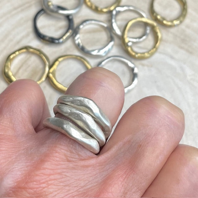 Alchemist Stacking Rings Silver shown on  hand with various Element Rings in background 