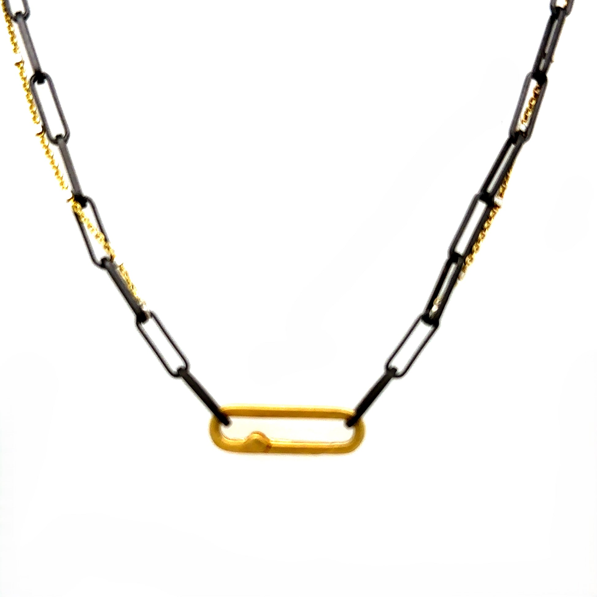 A harmonious blend of two worlds in one exquisite piece. This necklace features two chains: one in sophisticated black oxidized sterling silver and the other in luxurious 14K gold-filled metal. The contrasting tones create a subtle yet striking visual interest, perfect for those who appreciate nuanced style. The necklace comes complete with our signature paperclip connector, allowing you to easily add talismans for a personalized touch.