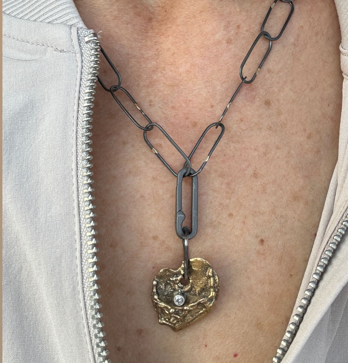 The Love Talisman Necklace on a person wearing a white jacket.