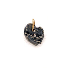 The Love Talisman designed as a heart-shaped talisman with textured patterns and a small diamond at the top center.
